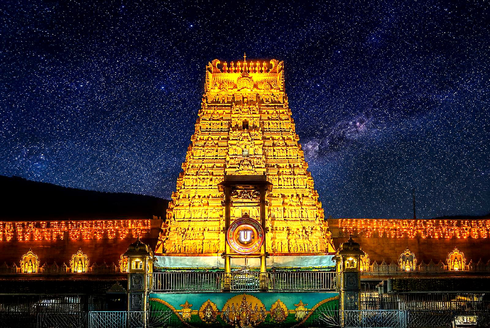 Tirumala gopuram illuminated against a starry night sky
