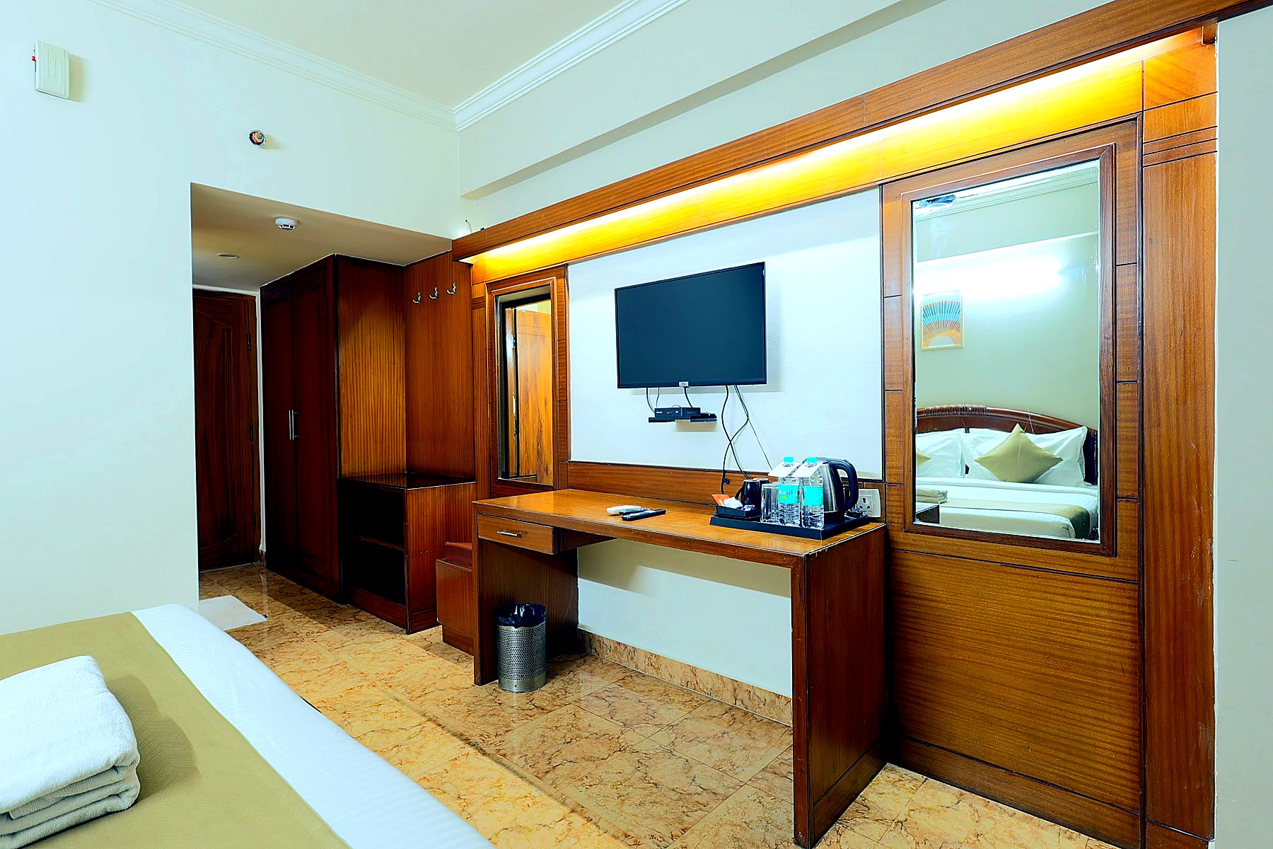 In-room workspace with vanity mirror and wall-mounted TV