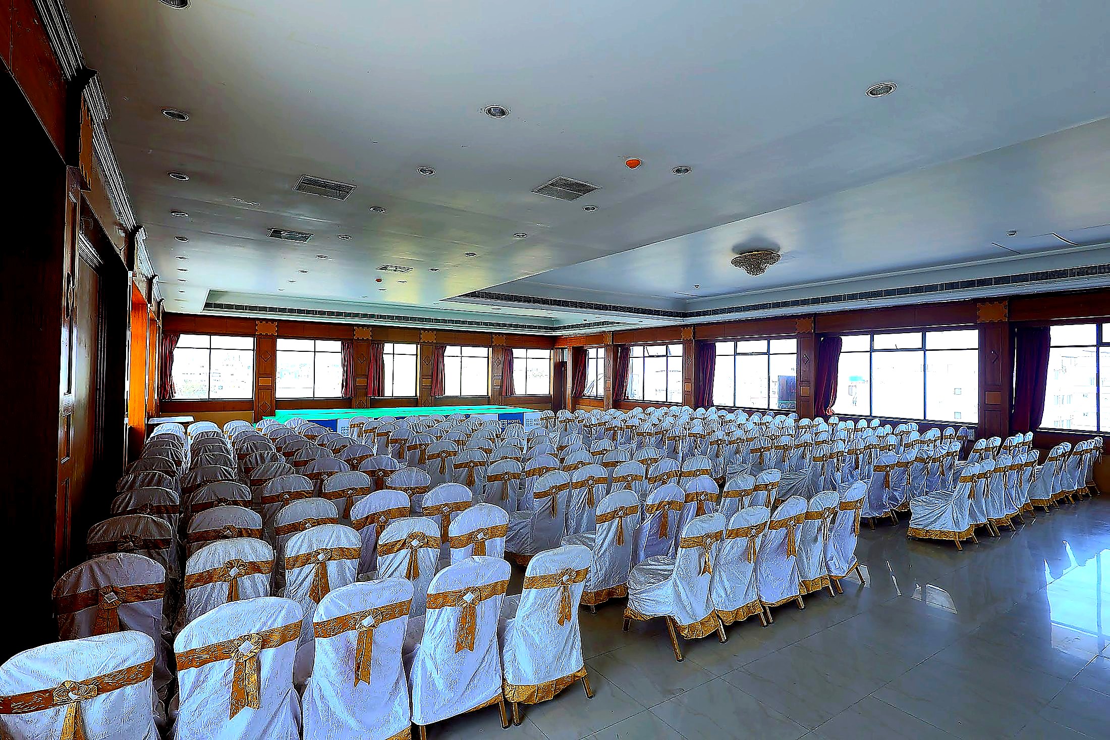 Banquet hall with linen-draped chairs and gold sashes