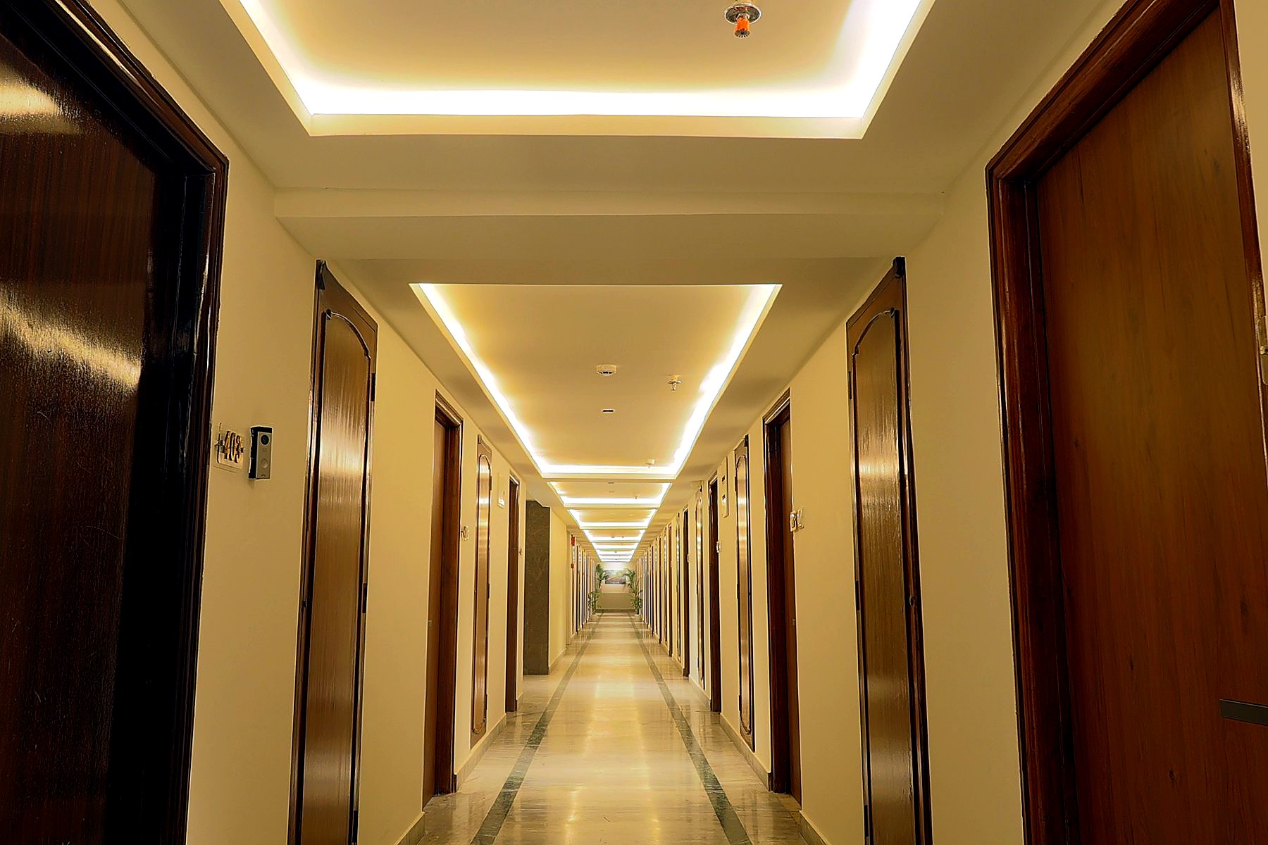 Symmetrical guest-room corridor with linear lighting