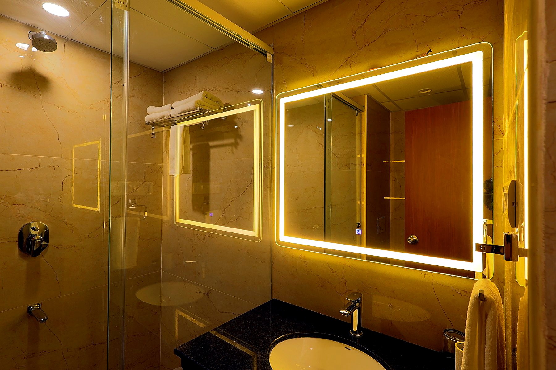 En-suite bathroom with backlit LED mirror and vanity
